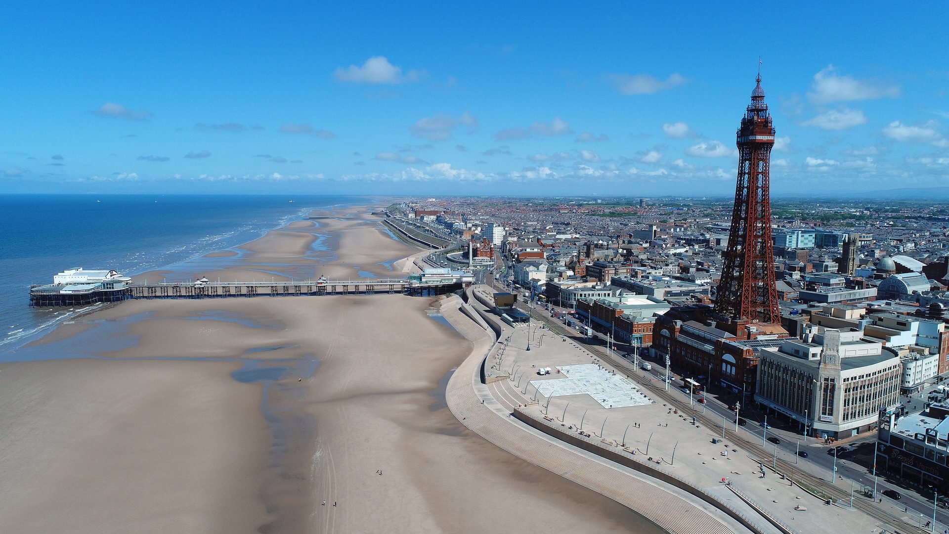 Blackpool Tower over the promenade and the beach, from the air